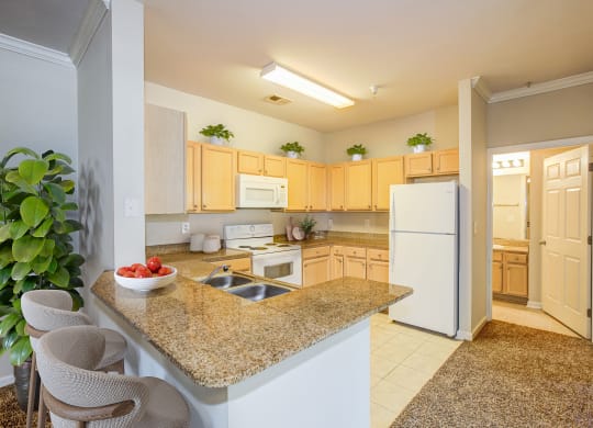 a kitchen with a granite counter top at Village on the Lake Apartments, Spring Lake, North Carolina